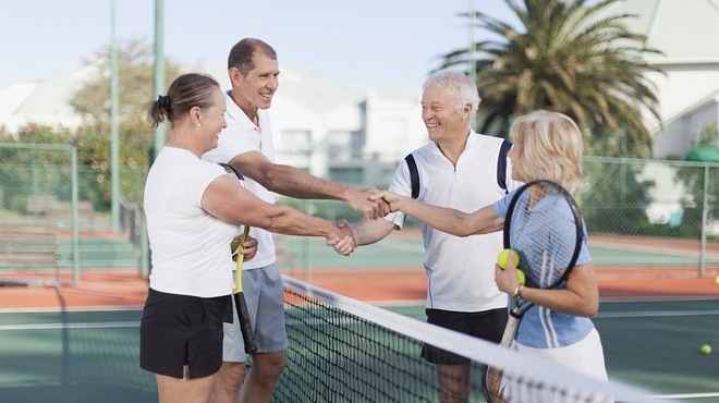 Group of active adults enjoying a game of tennis at Traditions at Lake Ruby