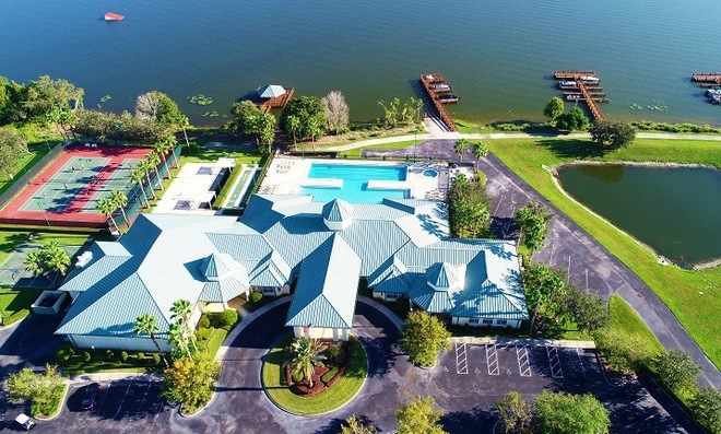 Aerial view of Traditions at Lake Ruby community surrounded by lush greenery and tranquil lake